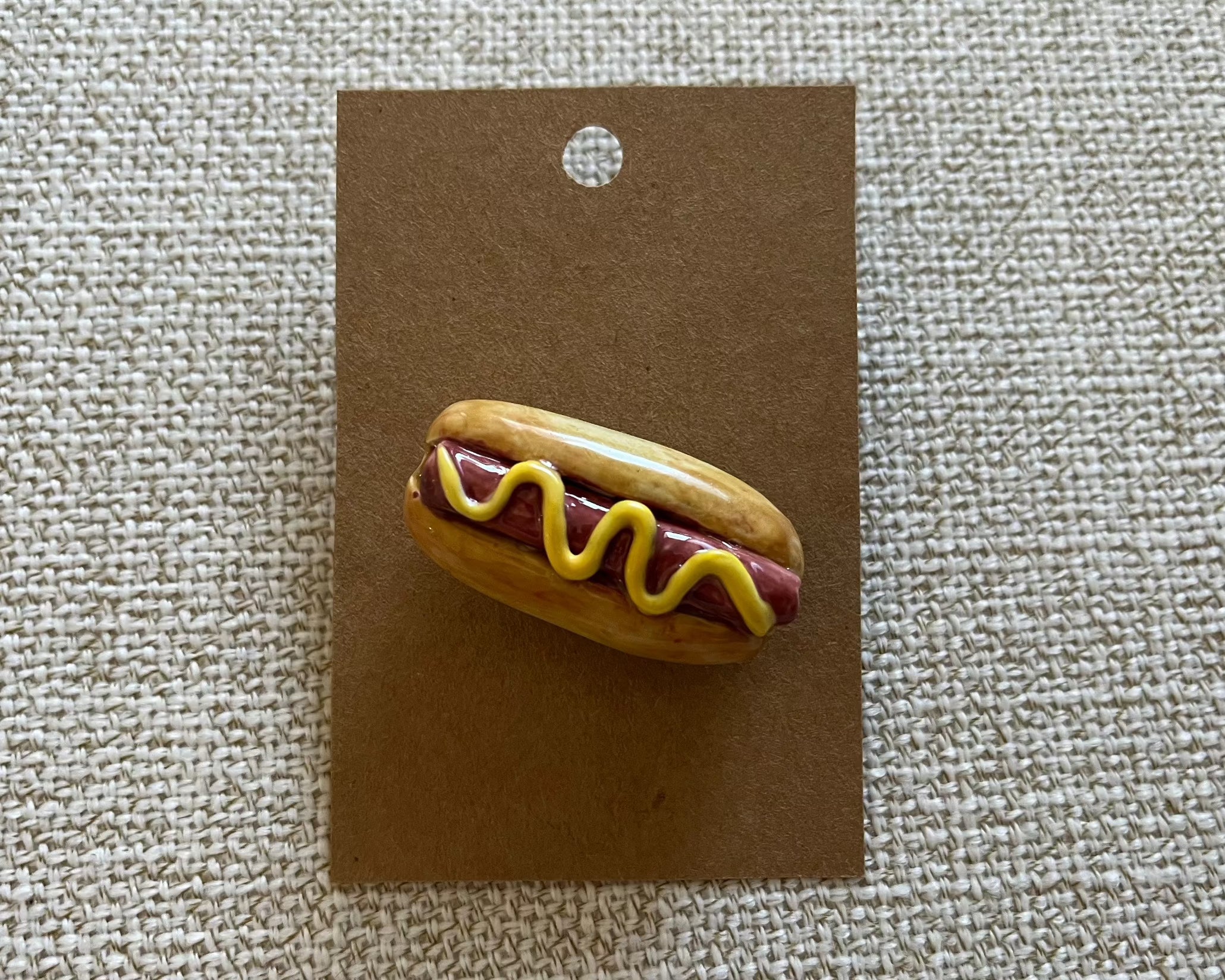 Handmade hot dog polymer clay brooch pin paper background