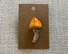 Handmade mushroom polymer clay brooch pin paper background