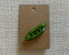 Handmade green peas polymer clay brooch pin paper background