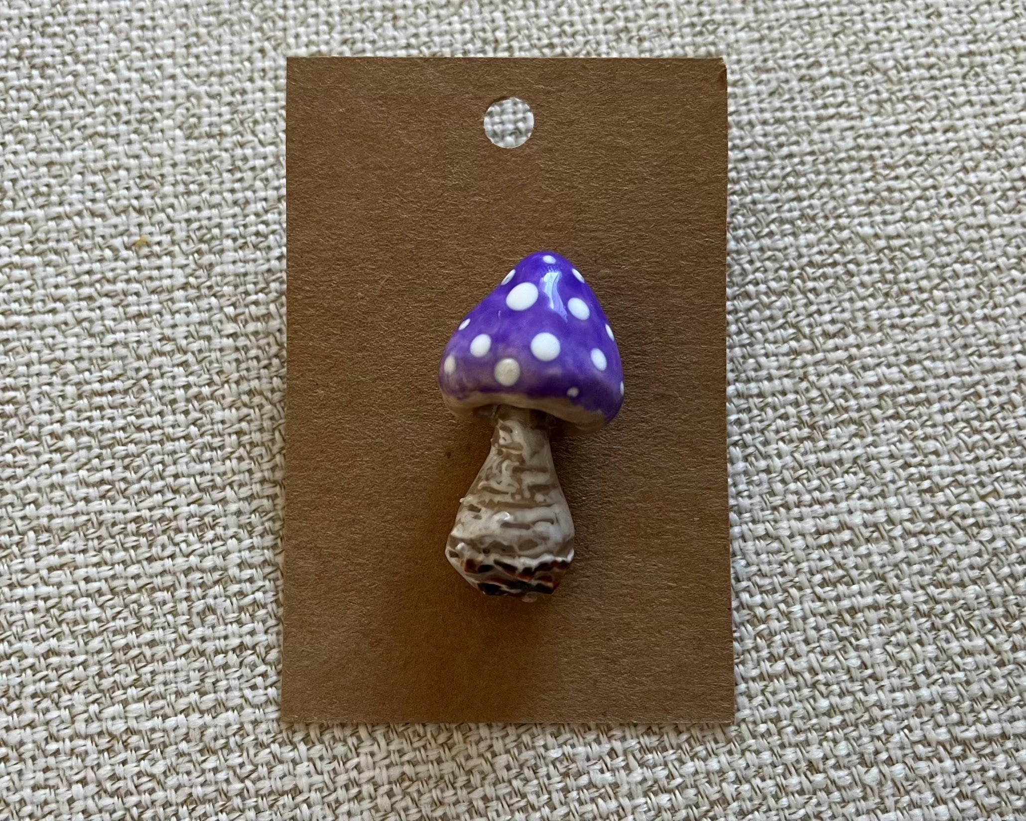 Handmade mushroom polymer clay brooch pin paper background